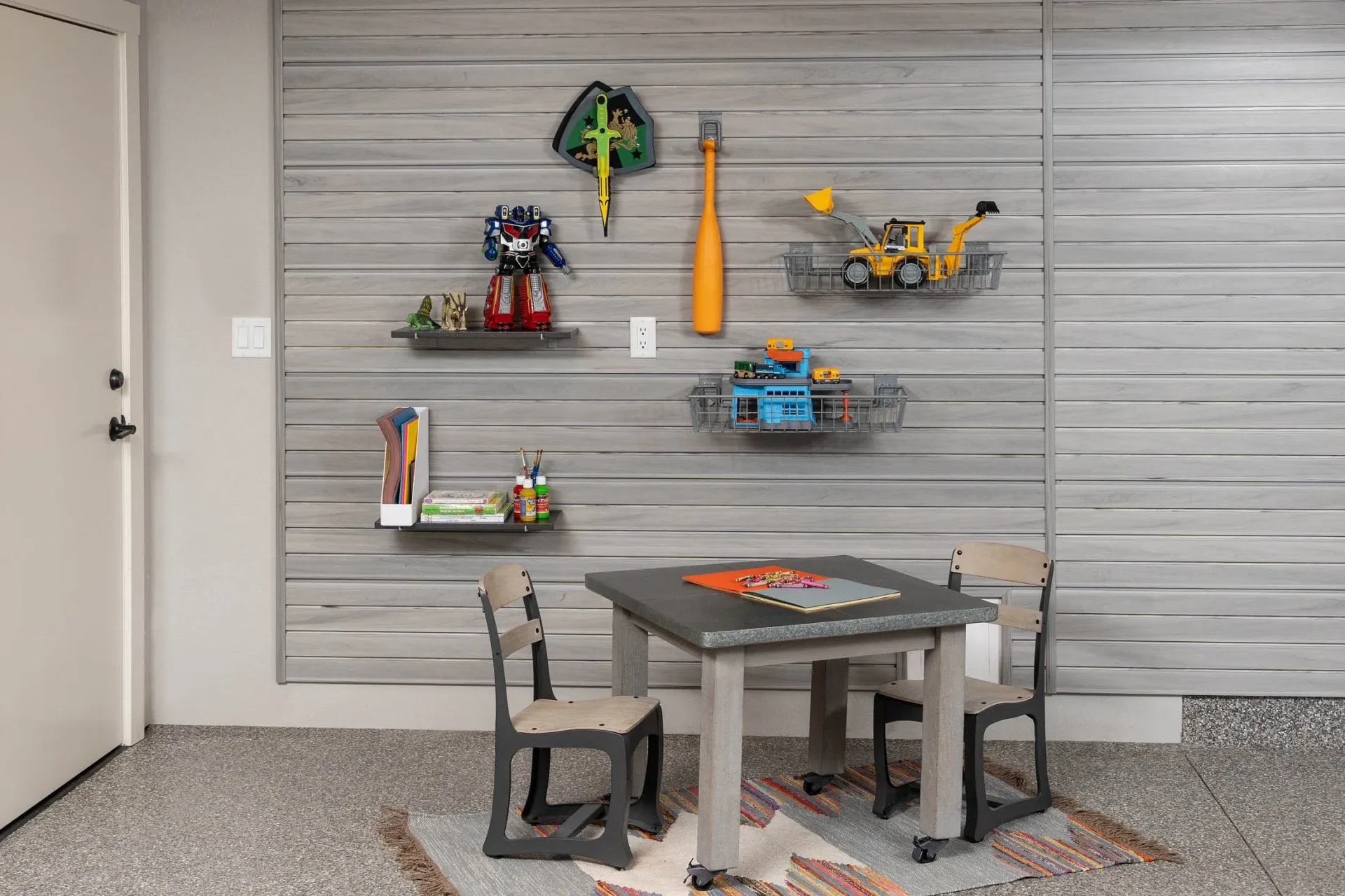 A table and chairs in front of a wall.