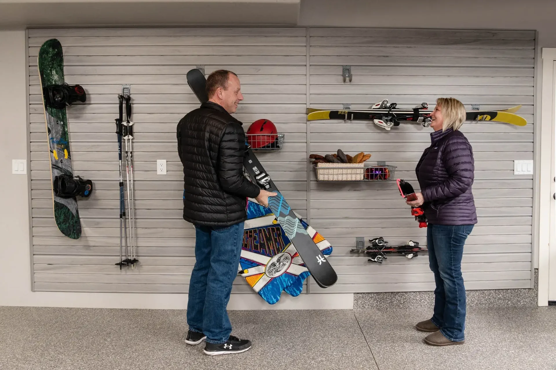 A man and woman holding skis in a room.