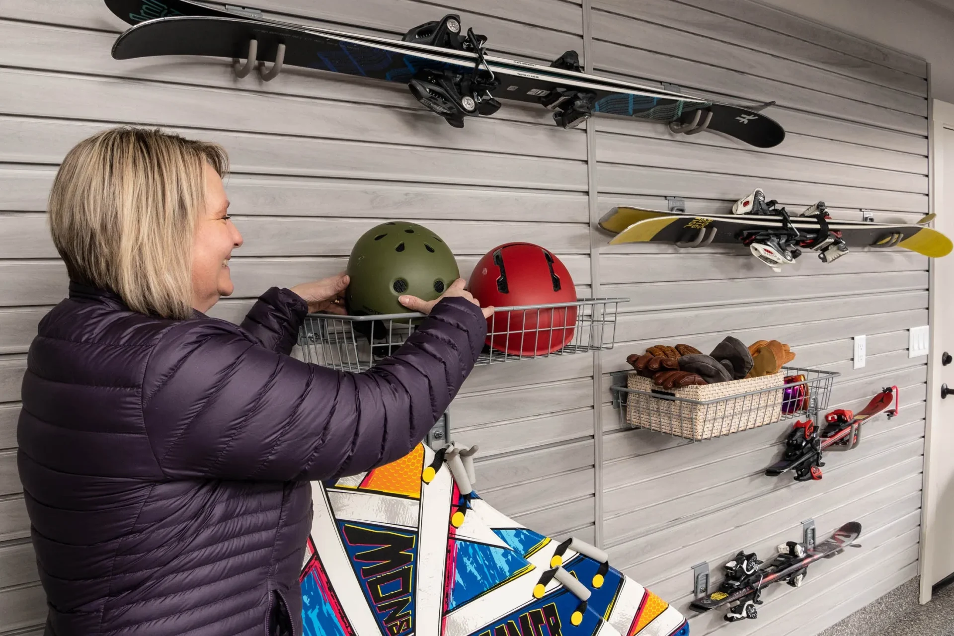 A woman is holding onto some helmets in her hands