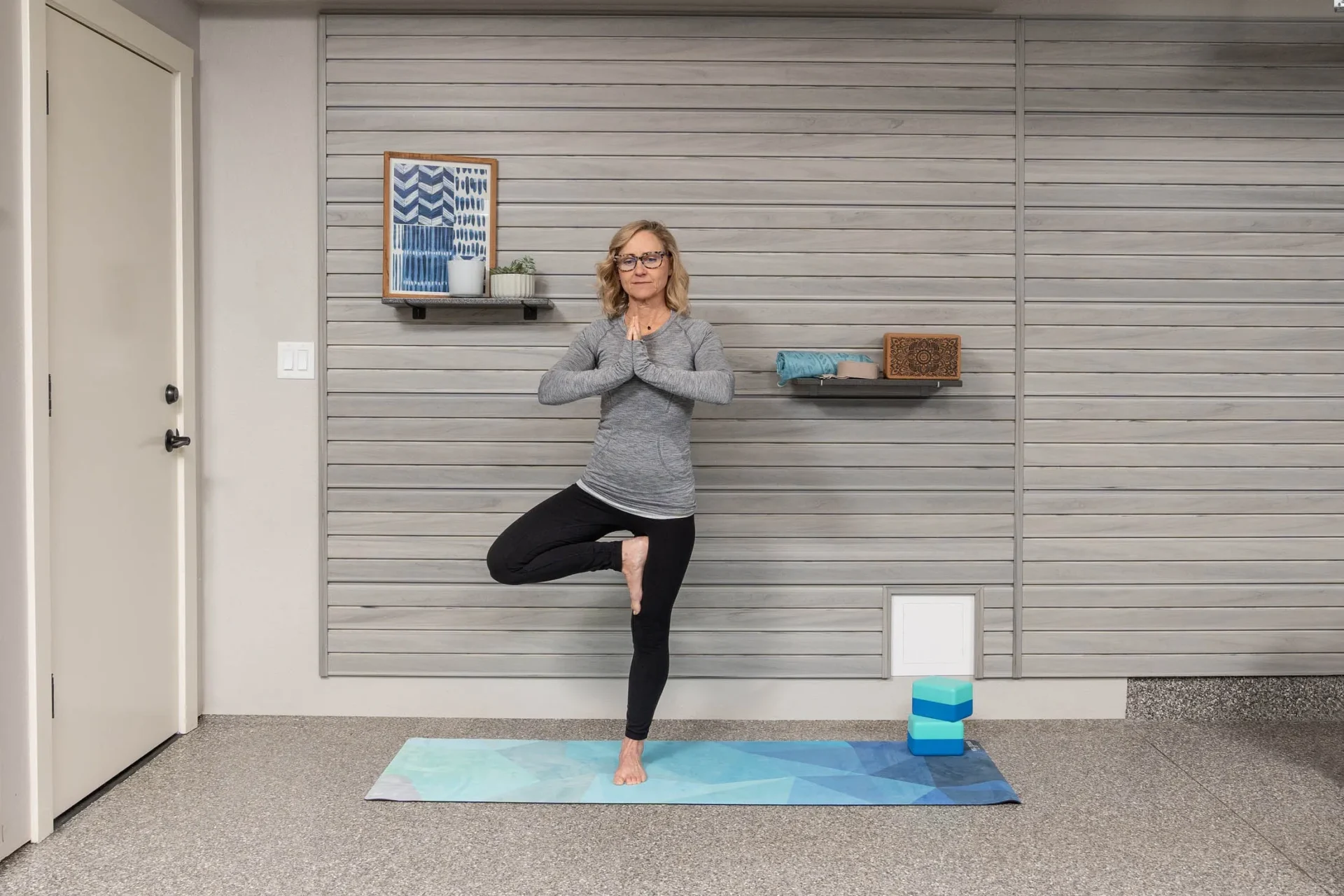 A woman is doing yoga in the living room.