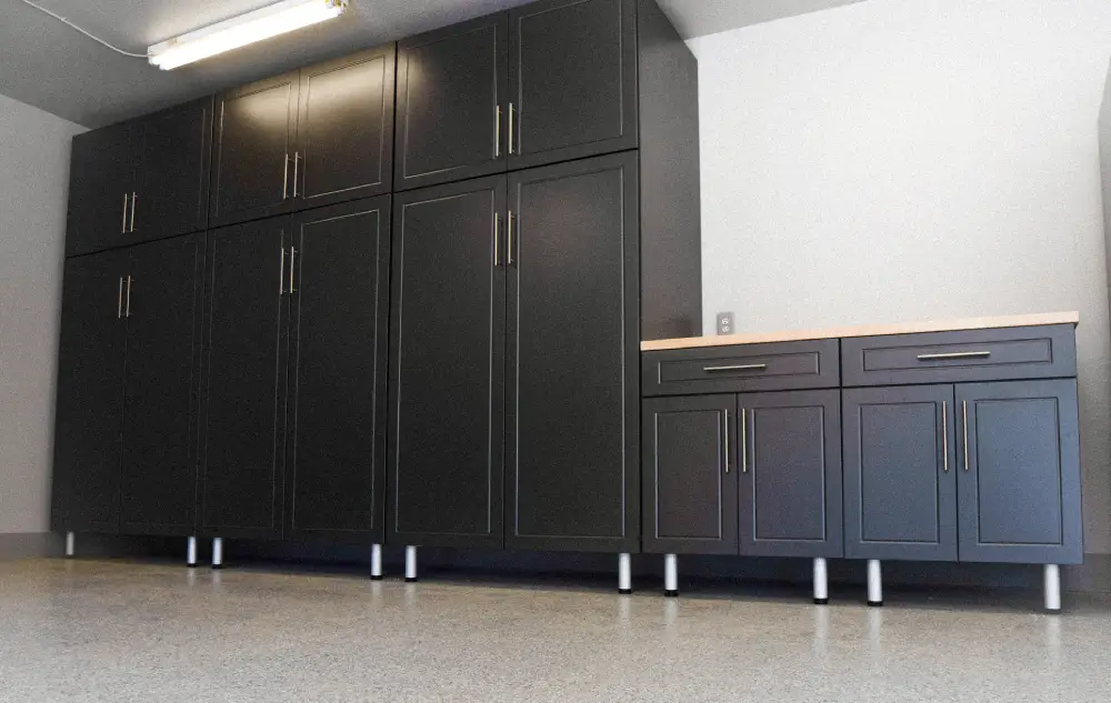 A garage with black cabinets and white counters