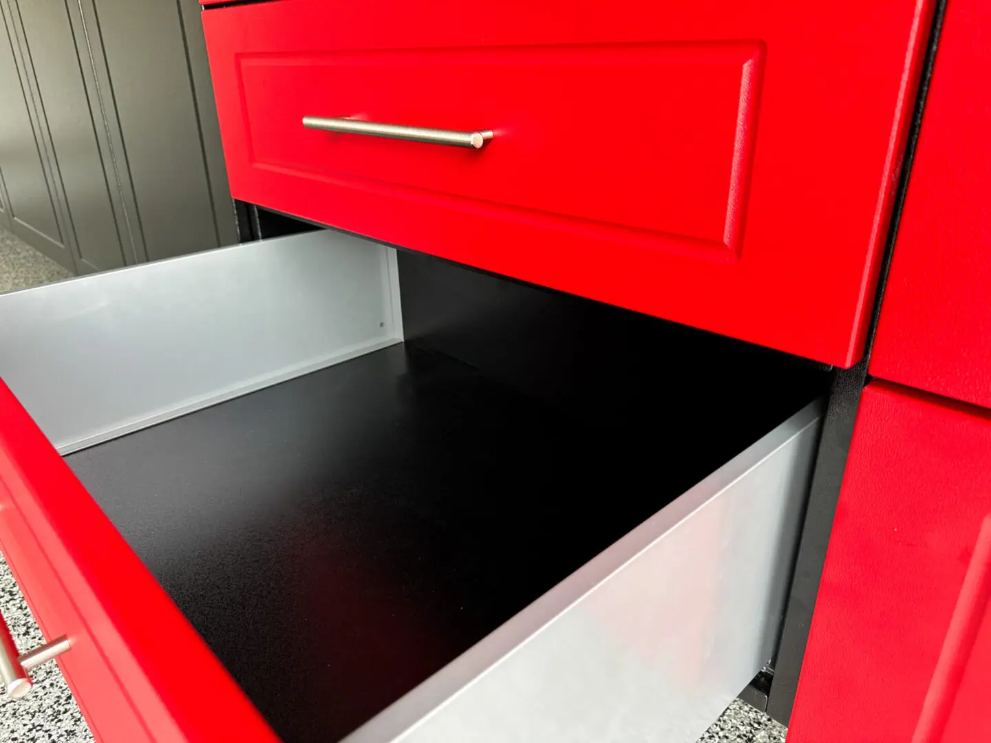 A red cabinet with black drawers and a metal handle.