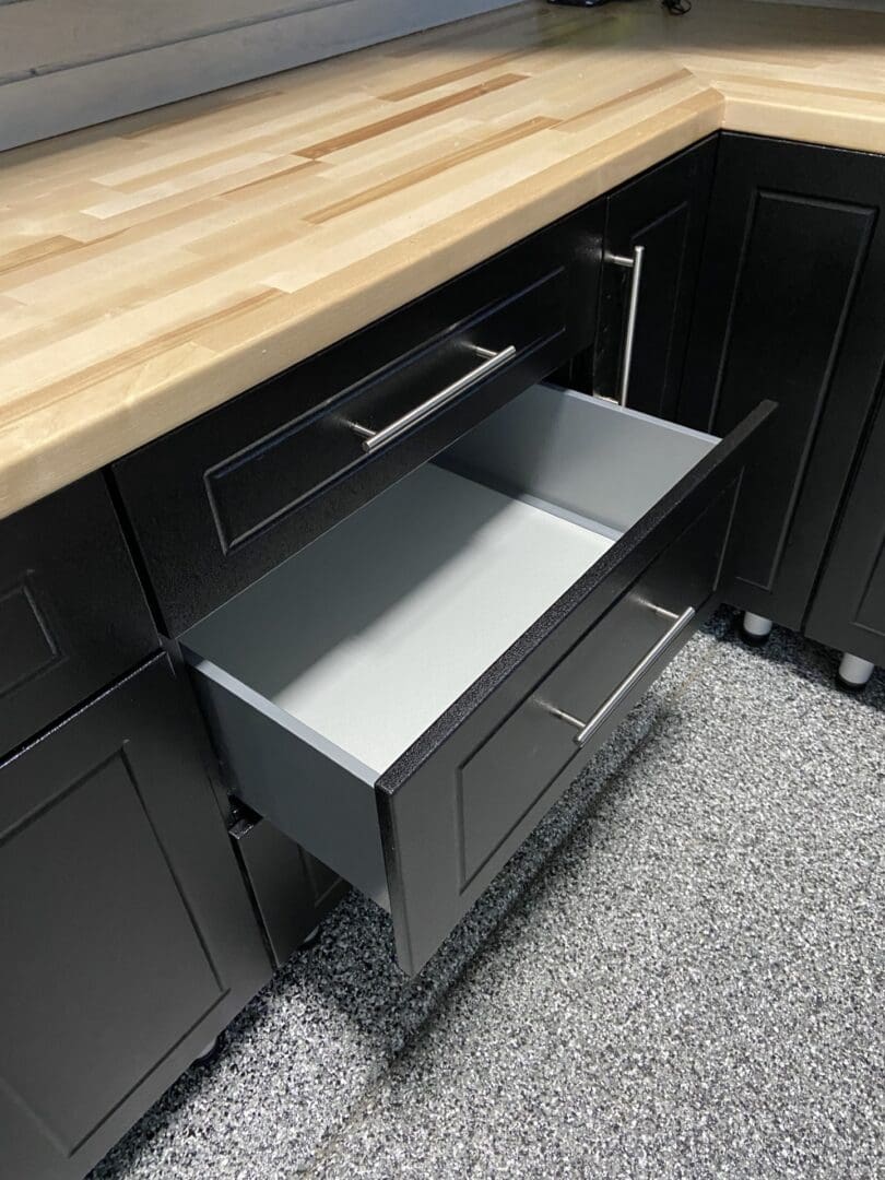 A kitchen with black cabinets and wooden counter tops.